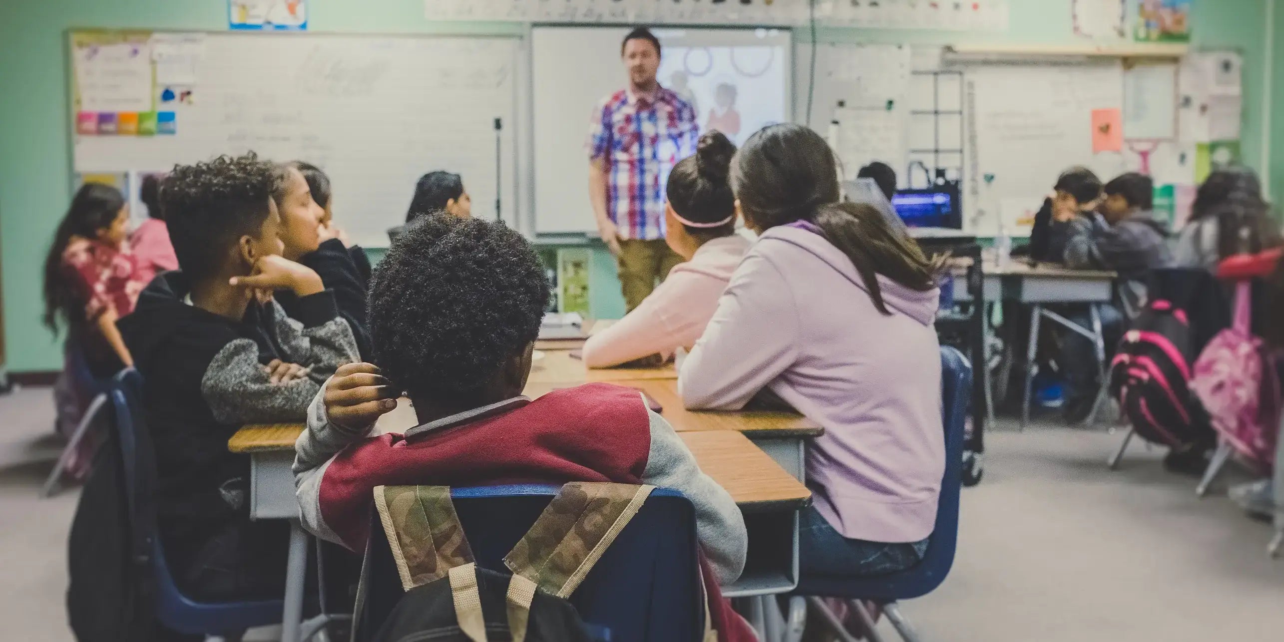 Man Teaching In a Crowded Classroom CURVD Supports Educators