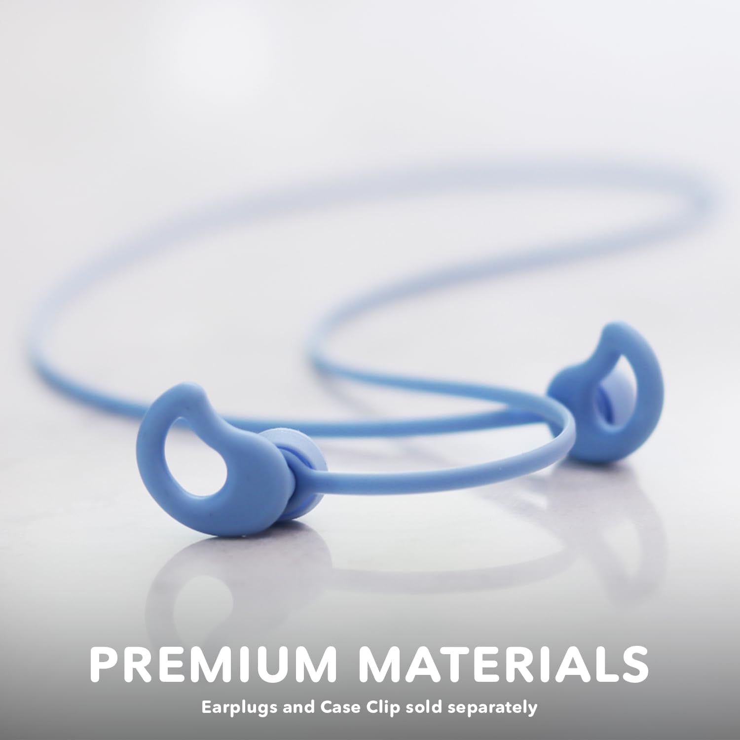 Close-up image of a blue strap with two ends that have circular loops, designed for securing compatible earplugs. Crafted from premium silicone, the background is a smooth, light-colored surface. The text at the bottom reads: "CURVD Earplugs Earplug Lanyard. Earplugs and Case Clip sold separately.