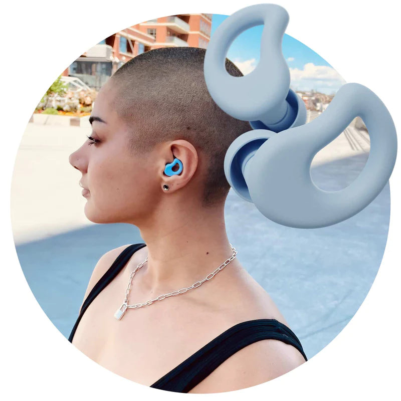 Blue CURVD Earplugs In front of Attractive Young Woman Wearing CURVD Earplug to Muffle Loud City Noise 