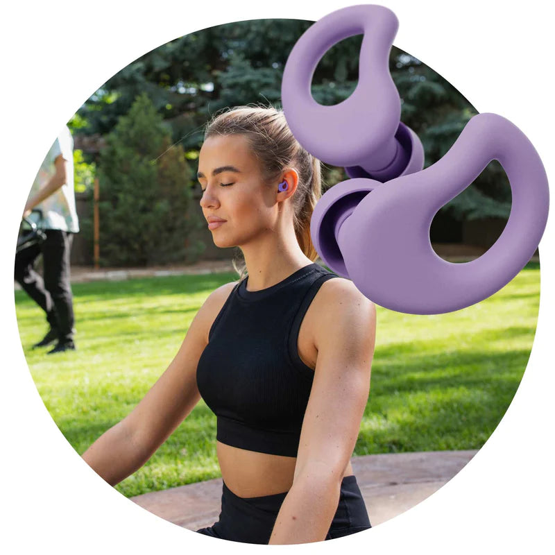 Purple CURVD Earplugs with Young Woman Relaxing Blocking Out Loud Noises while Wearing CURVD Ultra-soft, Comfortable Earplugs 